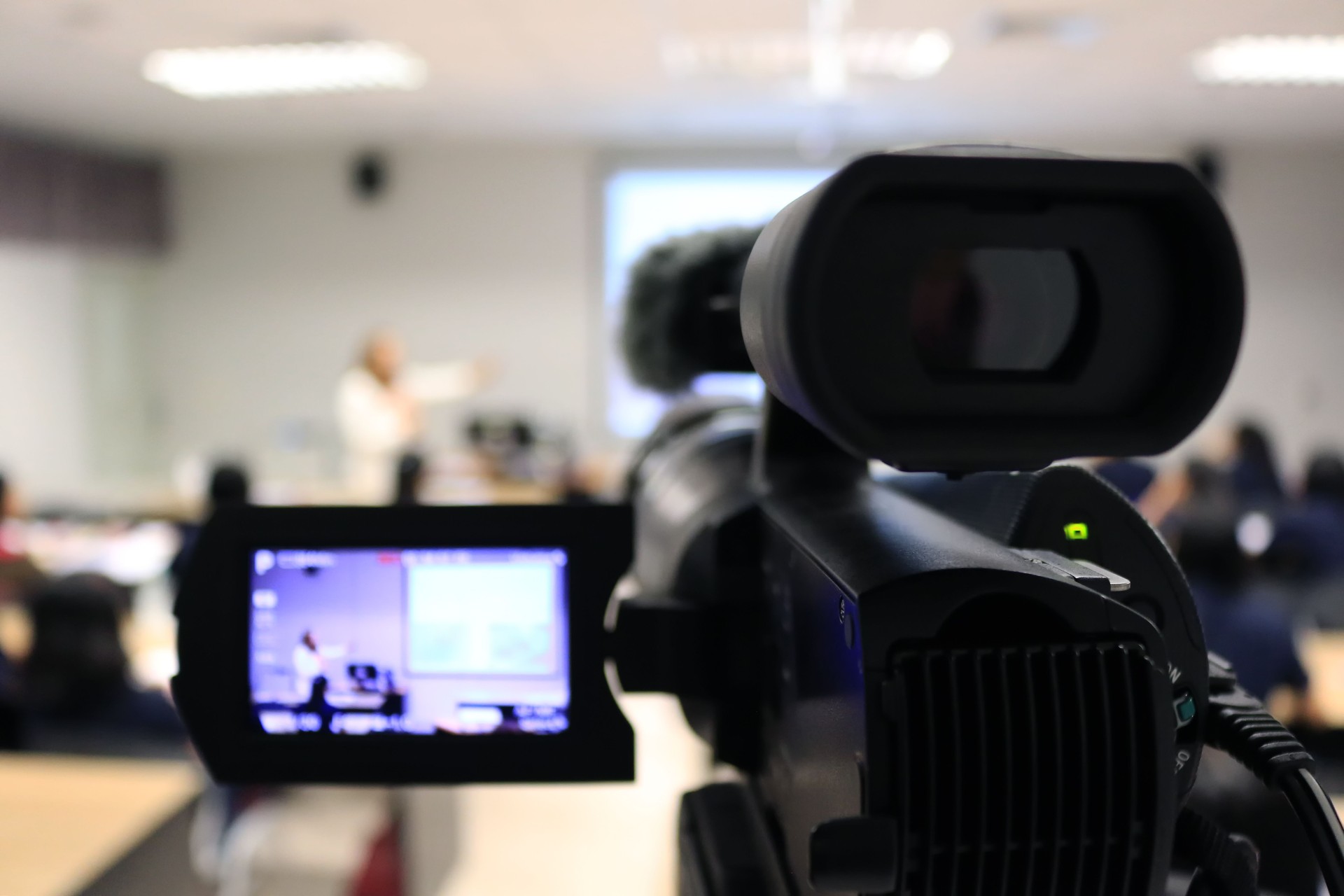 Photographer recording video lecturer and student learning by camcorder in classroom.